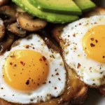 Sautéed mushrooms, fried eggs, and avocado on toasted bread.