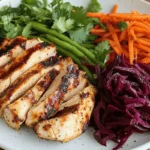 grilled chicken slices served with fresh veggie slaw, featuring beets, carrots, and green beans on a white plate.