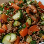 A bowl of Mediterranean-style ground beef stir fry with colorful vegetables and fresh herbs.